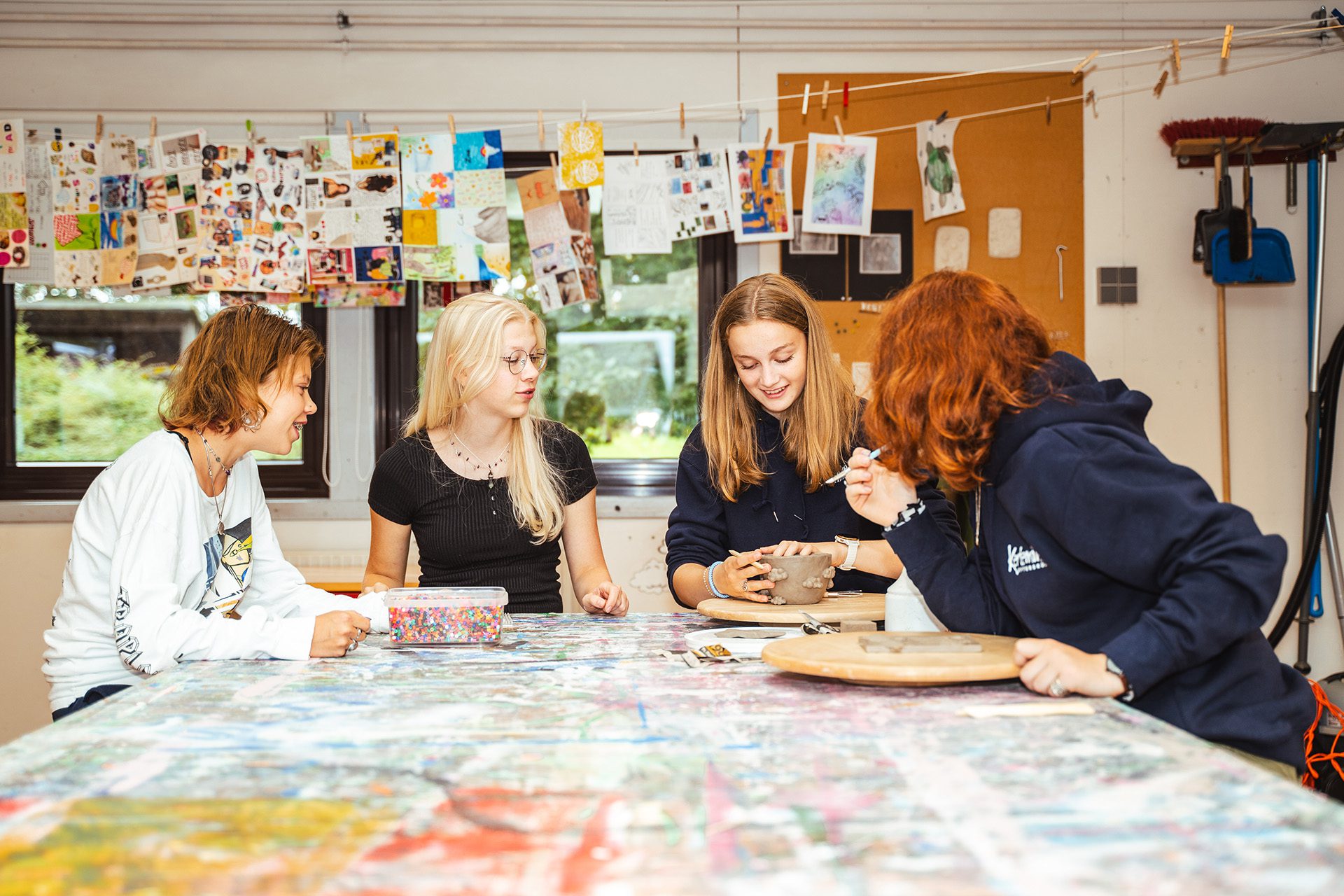 Pige arbejder med keramik og maling på efterskolens kunstlinje